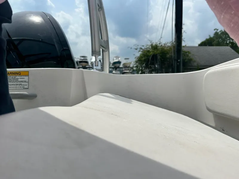 Slide: The Image of 2015 Bayliner Element E180 boat interior with engine, under a cloudy sky. - 24