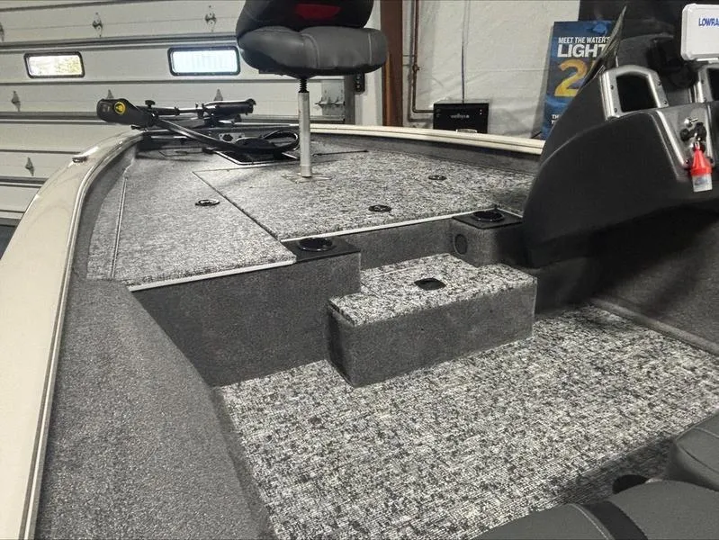 Slide: The Image of 2025 Tracker PT 175 TXW boat interior with carpeted deck and seating. - 3