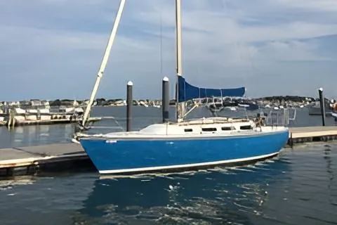 Slide: The Image of 1984 Catalina 36 Tall Rig sailboat docked in a marina, blue hull, calm waters. - 0