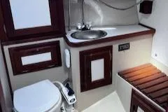 Slide: The Image of 1984 Catalina 36 Tall Rig bathroom with sink, toilet, and wooden accents. - 11
