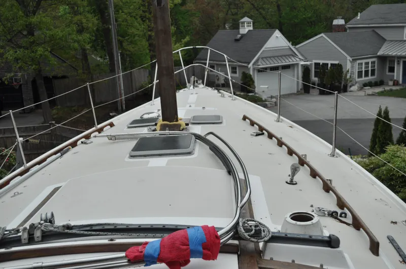 Slide: The Image of 1984 Catalina 36 Tall Rig sailboat deck with rigging, docked near residential area. - 17