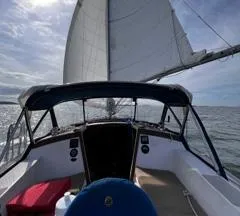 Slide: The Image of 1984 Catalina 36 Tall Rig sailboat on open water, sails unfurled under a cloudy sky. - 4