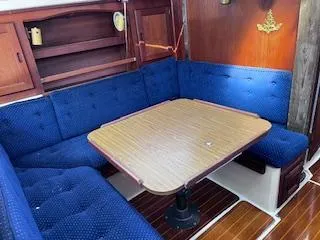 Slide: The Image of Interior of 1984 Catalina 36 Tall Rig sailboat with blue cushioned seating and wooden table. - 9