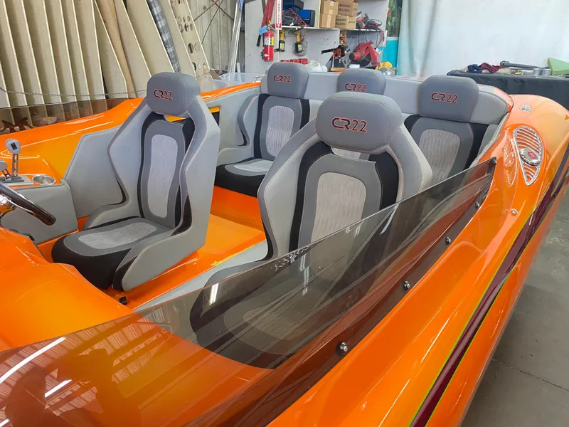 Slide: The Image of 2025 Essex Boats CR22 interior with orange and gray seating, showcasing modern design. - 4