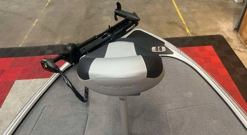 Slide: The Image of 2025 Nitro Z18 boat seat and trolling motor on a carpeted deck. - 7