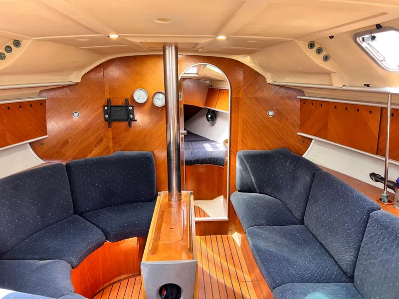 Slide: The Image of Interior of 1990 Beneteau First 41s5 sailboat with wood finish and blue seating. - 2