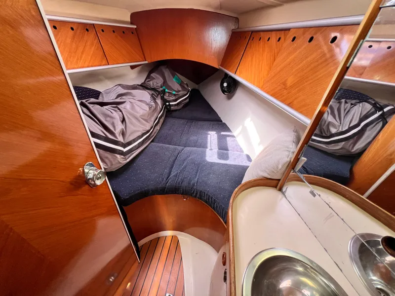 Slide: The Image of Cozy cabin interior of 1990 Beneteau First 41s5 sailboat with wood finish and compact sink. - 3