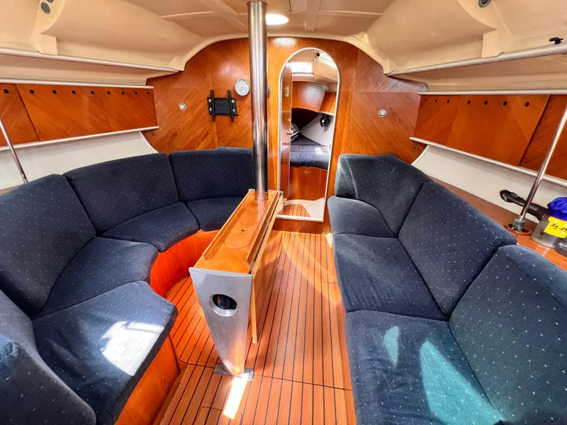 Slide: The Image of Luxurious interior of 1990 Beneteau First 41s5 sailboat with elegant wood finish and cozy seating. - 36