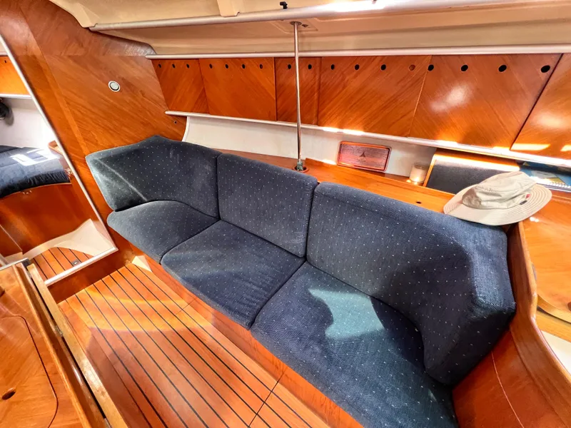 Slide: The Image of Interior of 1990 Beneteau First 41s5 yacht with blue sofa and wooden finish. - 38