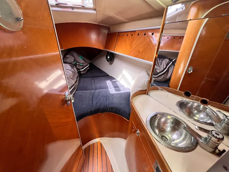 Slide: The Image of Cozy cabin interior of 1990 Beneteau First 41s5 sailboat with wooden finish and compact sink. - 41