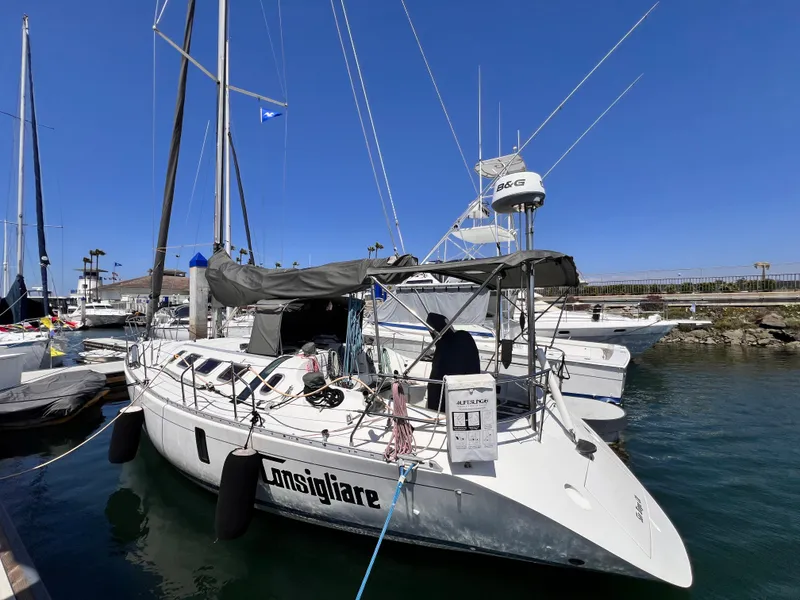 Slide: The Image of Beneteau First 41s5 sailboat, 1990 model, docked in a marina under clear blue skies. - 8