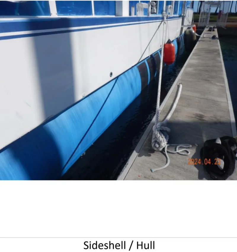 Slide: The Image of Custom 2010 Semi Sub Power Catamaran docked, showing sideshell and hull with fenders. - 23