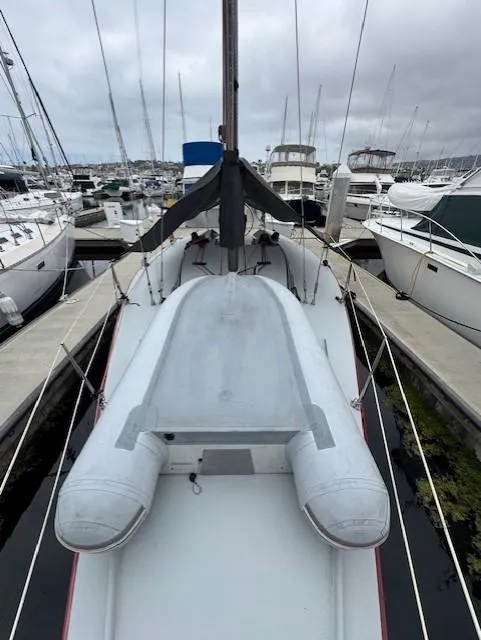 Slide: The Image of 1985 Farr PERFORMANCE sailboat docked at marina, surrounded by other boats under cloudy skies. - 11