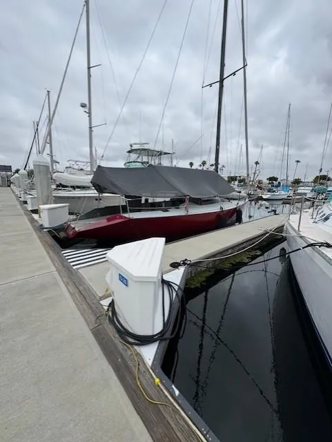 Slide: The Image of 1985 Farr PERFORMANCE sailboat docked at marina under cloudy skies. - 14