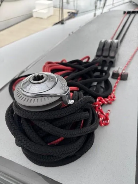 Slide: The Image of Coiled ropes on 1985 Farr PERFORMANCE sailboat deck, featuring winch and cleats. - 17