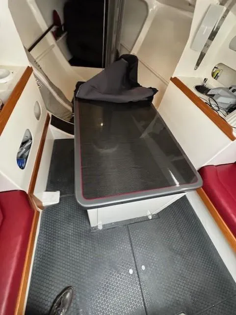 Slide: The Image of Interior of a 1985 Farr PERFORMANCE boat with red seating and a central table. - 20