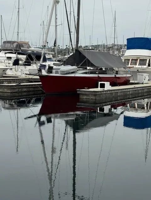 Slide: The Image of Red Farr PERFORMANCE 1985 sailboat docked in a marina, surrounded by other boats. - 3