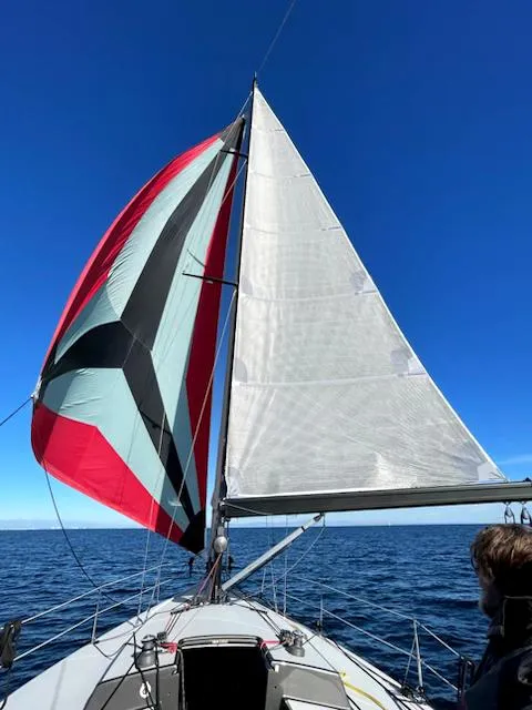 Slide: The Image of 1985 Farr PERFORMANCE sailboat with colorful spinnaker on open sea under clear blue sky. - 32