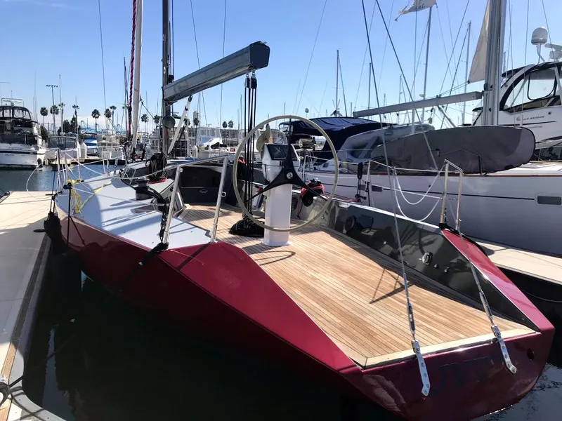 Slide: The Image of 1985 Farr PERFORMANCE sailboat docked at marina, featuring sleek red hull and wooden deck. - 4