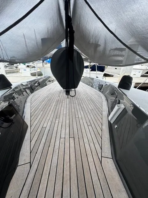 Slide: The Image of 1985 Farr PERFORMANCE yacht deck with wooden finish, docked at a marina. - 7
