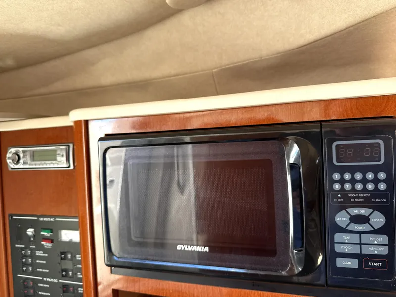 Slide: The Image of Microwave and control panel inside 2009 Sea Ray 230 Sundancer boat cabin. - 10