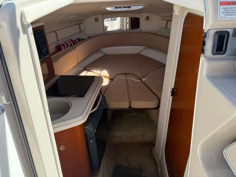 Slide: The Image of 2009 Sea Ray 230 Sundancer cabin interior with kitchenette and seating area. - 3