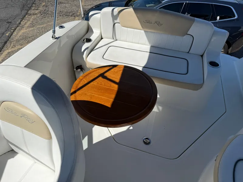 Slide: The Image of 2009 Sea Ray 230 Sundancer boat interior with seating and wooden table. - 6