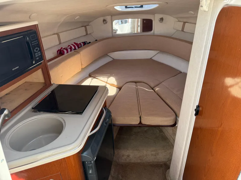 Slide: The Image of 2009 Sea Ray 230 Sundancer cabin interior with kitchenette and seating area. - 8