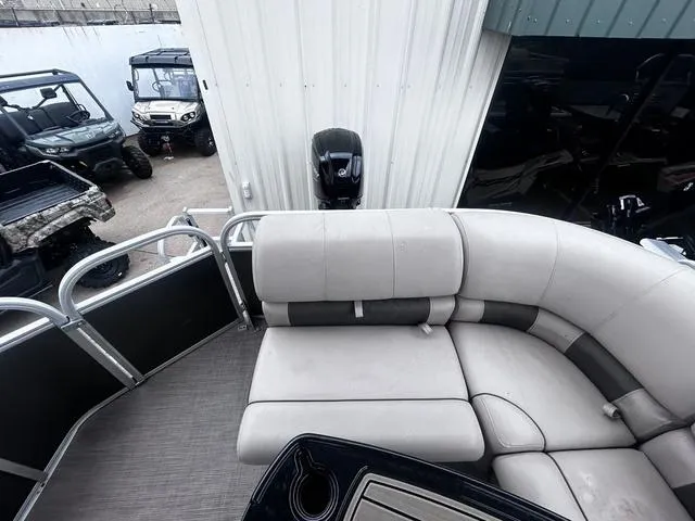 Slide: The Image of 2022 Sun Tracker PARTY BARGE® 20 DLX pontoon boat with plush seating and outdoor vehicles nearby. - 15