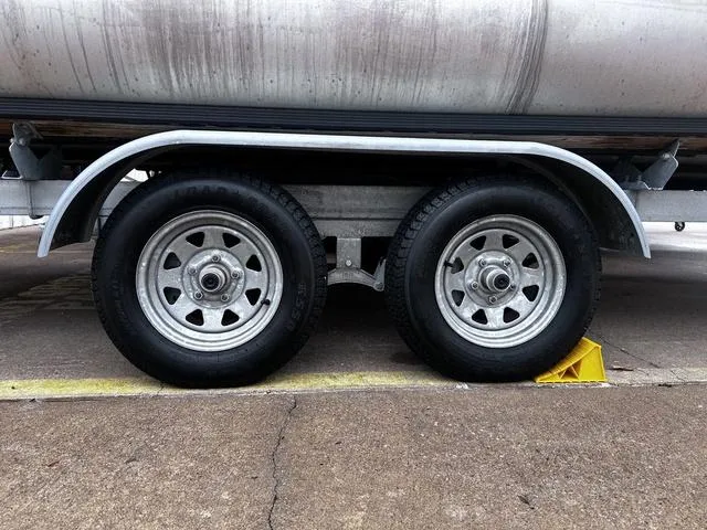 Slide: The Image of Trailer wheels of a 2022 Sun Tracker PARTY BARGE® 20 DLX, secured with a yellow wheel chock. - 3