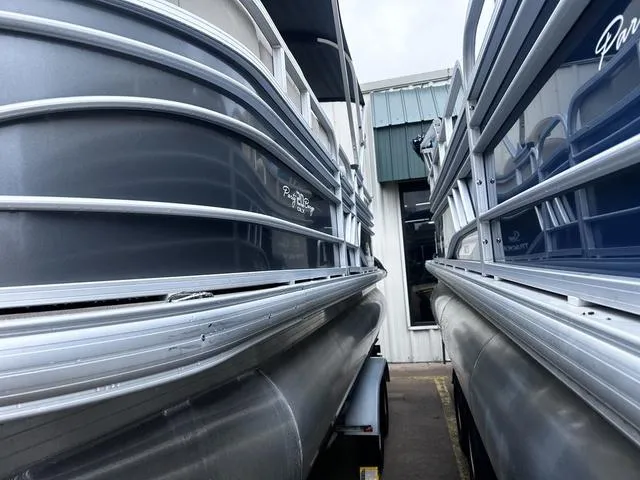 Slide: The Image of 2022 Sun Tracker PARTY BARGE® 20 DLX pontoon boats side by side in storage. - 9