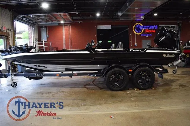Slide: The Image of 2023 Bass Cat Puma STS boat displayed indoors at Thayer's Marine showroom. - 10