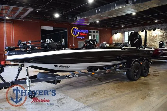 Slide: The Image of 2023 Bass Cat Puma STS boat displayed indoors at Thayer's Marine showroom. - 11
