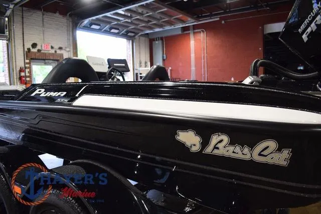 Slide: The Image of 2023 Bass Cat Puma STS boat in showroom, side view with logo visible. - 12