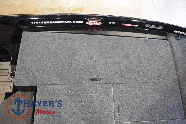 Slide: The Image of 2023 Bass Cat Puma STS boat deck with Thayer's Marine branding and carpeted storage compartments. - 29