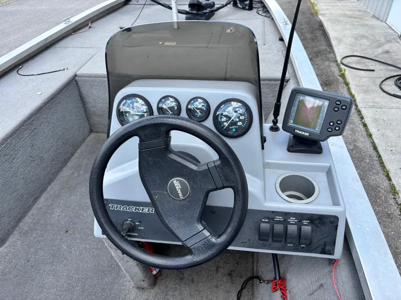 Slide: The Image of 1995 Bass Tracker Pro 18 boat dashboard with steering wheel and fish finder. - 6