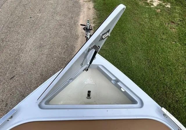 Slide: The Image of Open storage compartment on 2025 Cobalt R6 Surf boat, parked on grass. - 12