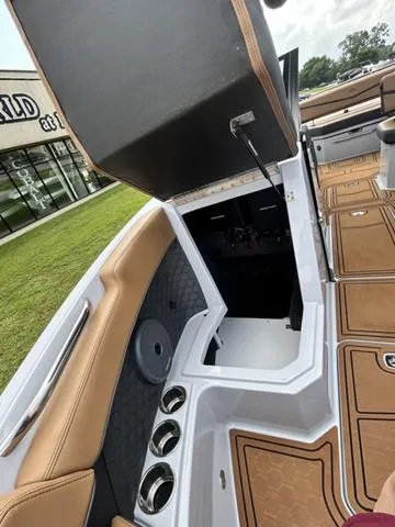 Slide: The Image of 2025 Cobalt R6 Surf boat interior with open storage compartment and cup holders. - 16