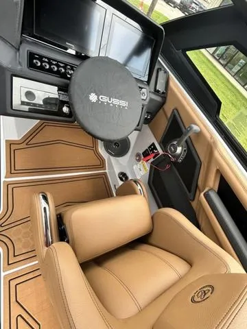 Slide: The Image of 2025 Cobalt R6 Surf boat interior with tan leather seating and modern dashboard controls. - 22