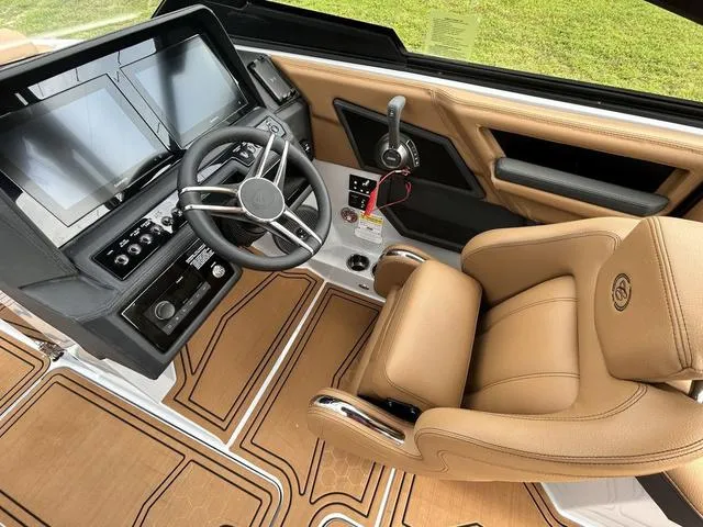 Slide: The Image of Luxurious 2025 Cobalt R6 Surf boat interior with modern dashboard and tan leather seating. - 23