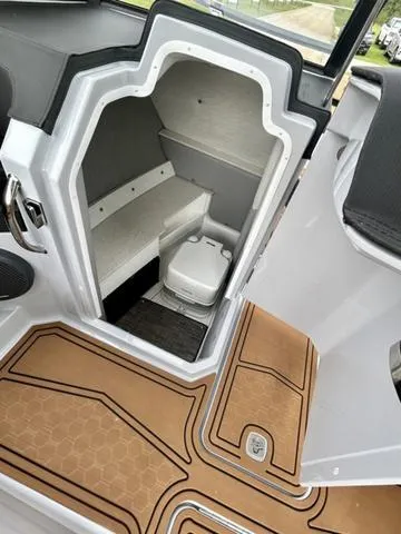 Slide: The Image of 2025 Cobalt R6 Surf boat interior with compact toilet and seating area. - 31
