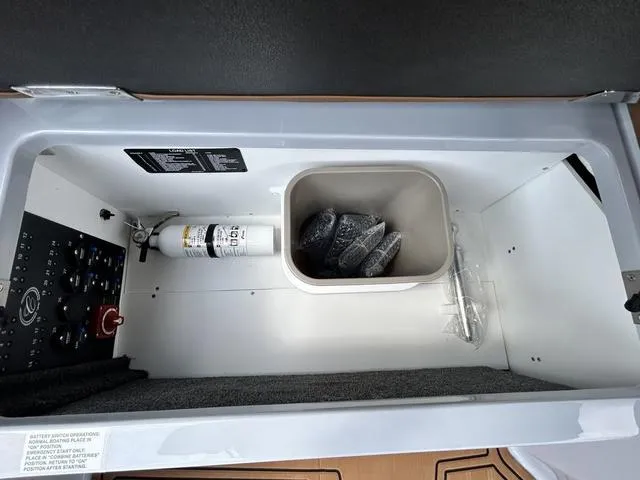 Slide: The Image of Storage compartment of 2025 Cobalt R6 Surf boat with fire extinguisher and accessories. - 37