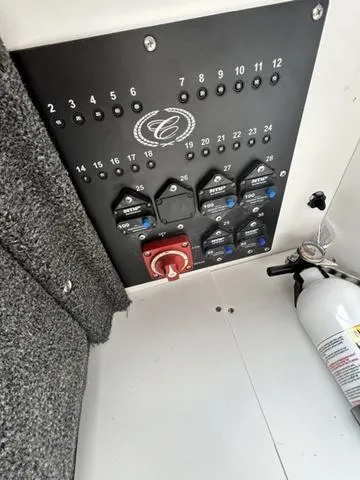 Slide: The Image of Control panel of 2025 Cobalt R6 Surf boat with switches and fire extinguisher. - 38