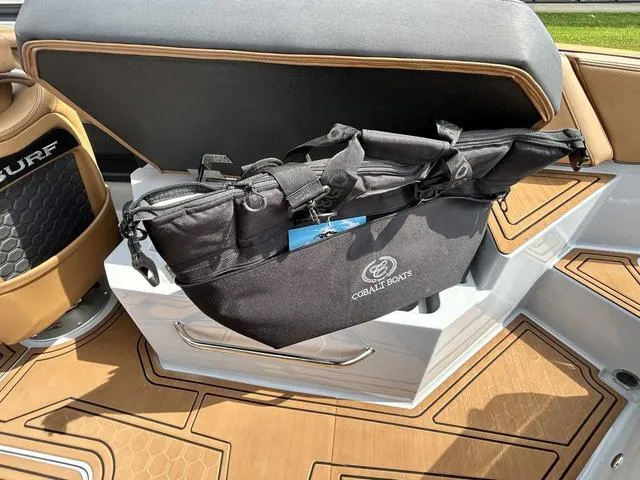 Slide: The Image of 2025 Cobalt R6 Surf boat interior with storage compartment and branded bag. - 44
