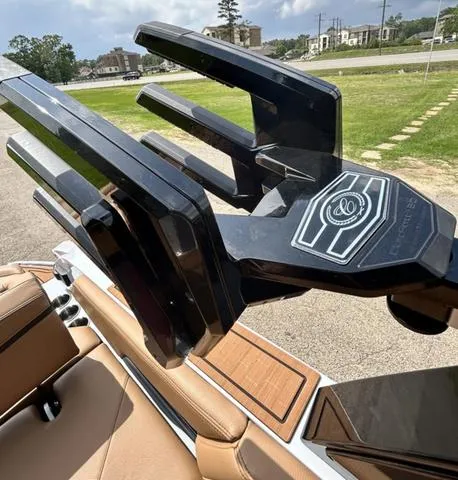 Slide: The Image of 2025 Cobalt R6 Surf boat with sleek black wakeboard rack and luxurious tan interior. - 46