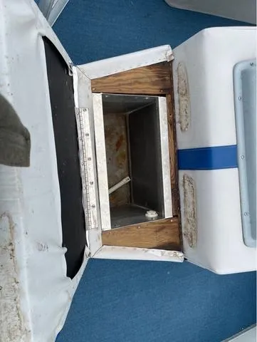 Slide: The Image of 1995 Sun Tracker BASS BUGGY 18 boat storage compartment with blue and white seating. - 10