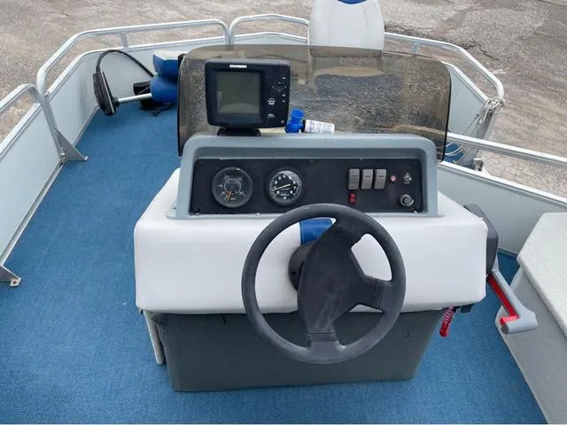 Slide: The Image of 1995 Sun Tracker BASS BUGGY 18 boat dashboard with steering wheel and navigation equipment. - 12