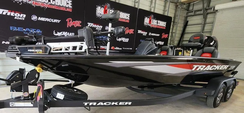 Slide: The Image of 2025 Tracker SAVAGE™ 215 boat on trailer in showroom, featuring sleek black design. - 4