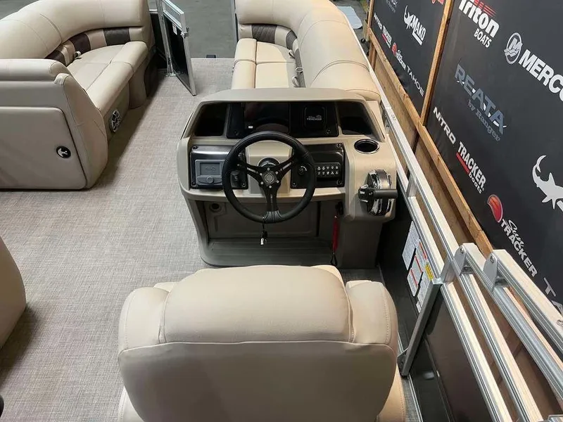 Slide: The Image of 2025 Sun Tracker PARTY BARGE® 20 DLX interior with beige seating and steering console. - 4