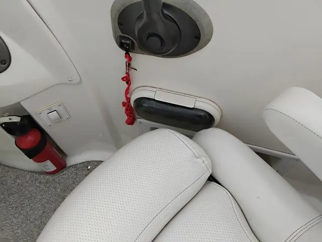 Slide: The Image of 2004 Sylvan 2240 Deck Boat interior with ignition key, fire extinguisher, and white seating. - 11